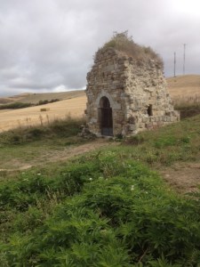 The remains of a building, on the side of the path